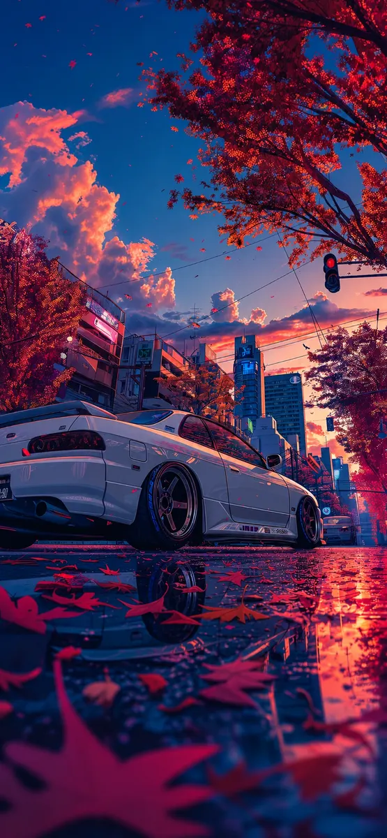 A white sports car is parked on a wet city street with red autumn leaves scattered on the ground under a vibrant sunset sky.
